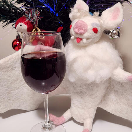BG3 Astarion - Batstarion Needle felted figure of Astarion from Baldur's Gate 3 as a white albino bat. There's a glass of what looks like wine in front of him.